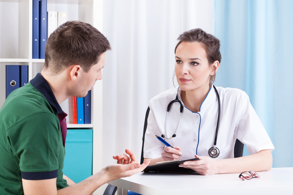 Doctor talking with patient and taking notes