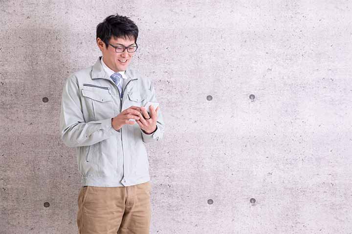 スマホで報告する男性 スマホで報告する男性