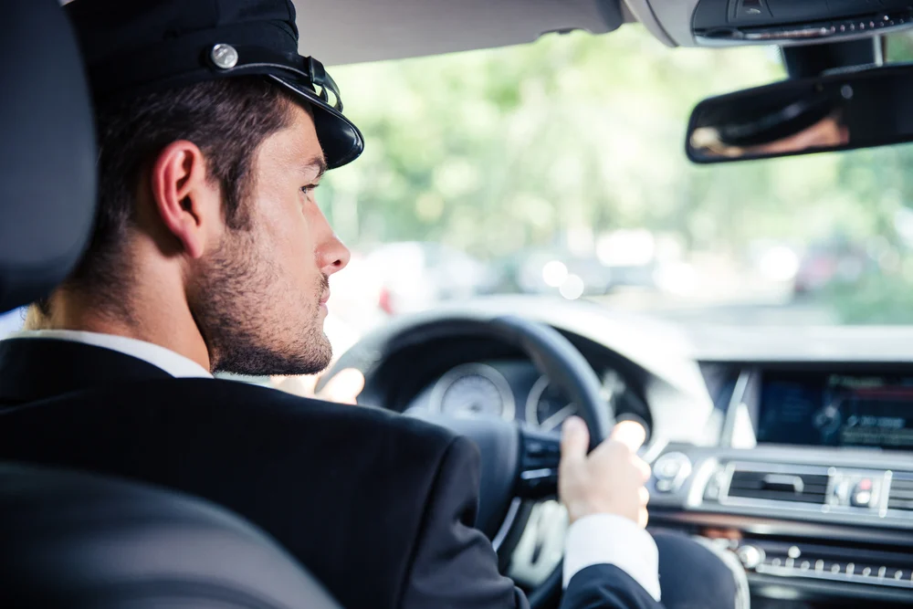 Portrait of a handsome male chauffeur riding car